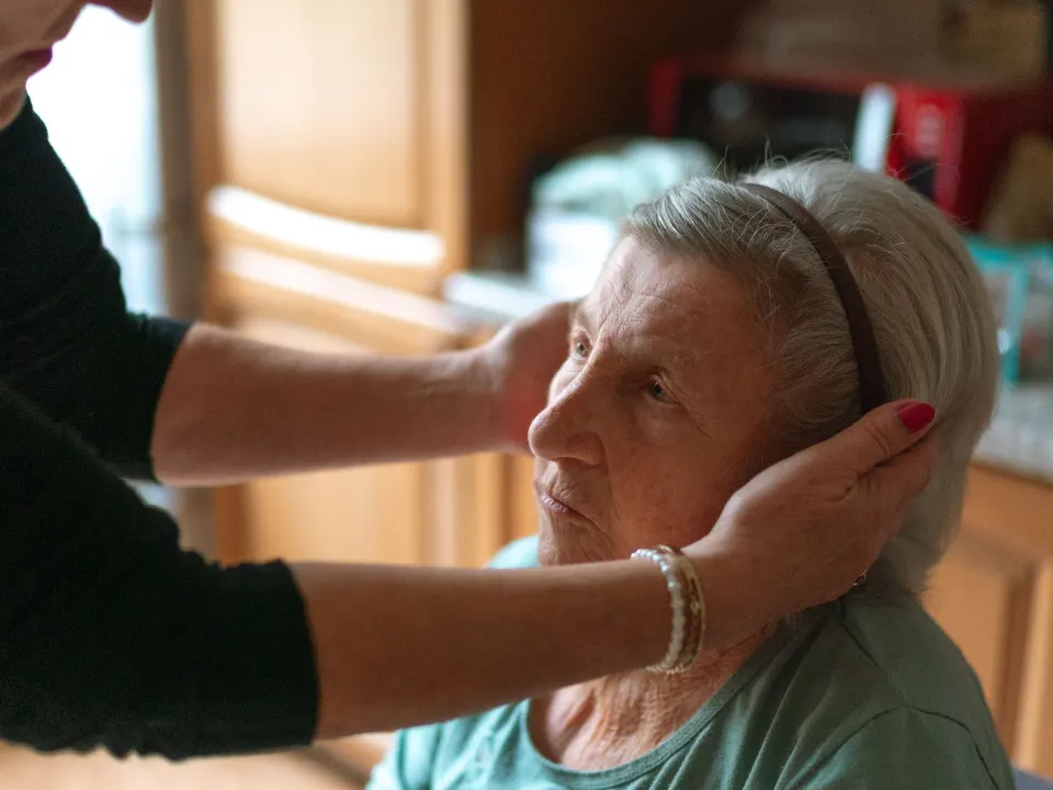 A trained caretaker looking after an elderly patient at home